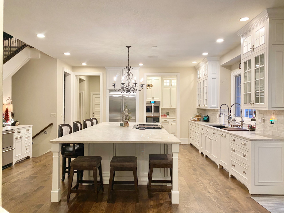 Immagine di una grande cucina classica con lavello sottopiano, ante a filo, ante bianche, paraspruzzi bianco, pavimento marrone e top bianco