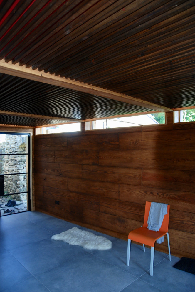 На фото: маленький универсальный домашний тренажерный зал в скандинавском стиле с коричневыми стенами, полом из фанеры, серым полом и кессонным потолком для на участке и в саду