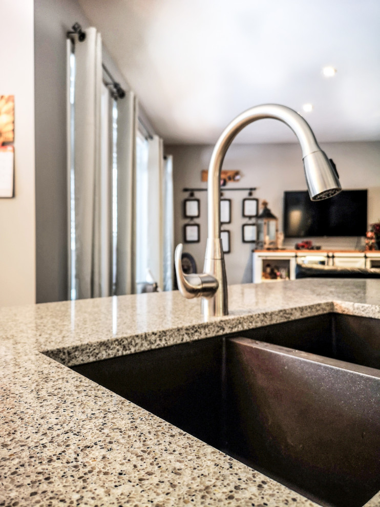 Example of a mid-sized mountain style l-shaped medium tone wood floor and brown floor eat-in kitchen design with a double-bowl sink, recessed-panel cabinets, dark wood cabinets, granite countertops, stainless steel appliances, an island and gray countertops
