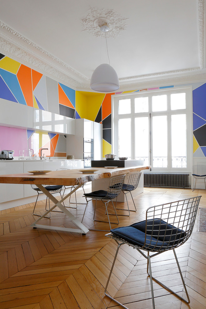 Design ideas for a mid-sized contemporary open plan dining in Paris with multi-coloured walls and medium hardwood floors.