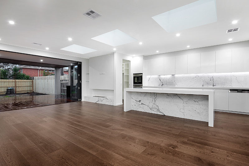 Photo of a mid-sized modern galley eat-in kitchen in Melbourne with open cabinets, white cabinets, solid surface benchtops, white splashback, porcelain splashback, stainless steel appliances, light hardwood floors, with island and an undermount sink.