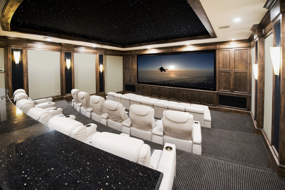 This is an example of an expansive traditional enclosed home theatre in Austin with beige walls, carpet, a projector screen and multi-coloured floor.