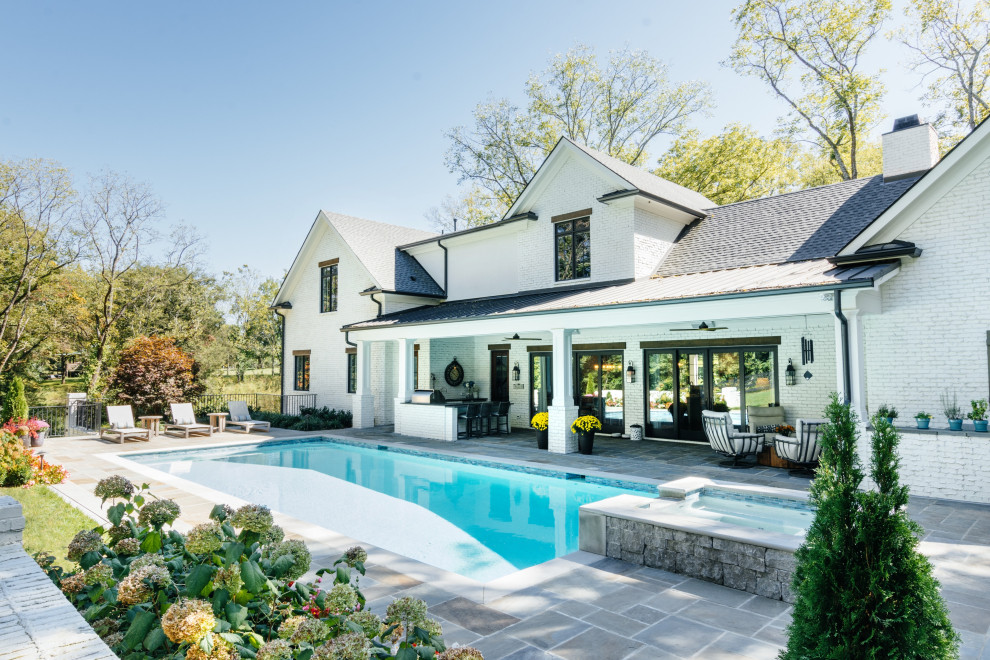 Ispirazione per una piscina classica rettangolare di medie dimensioni e dietro casa con una vasca idromassaggio e pavimentazioni in pietra naturale