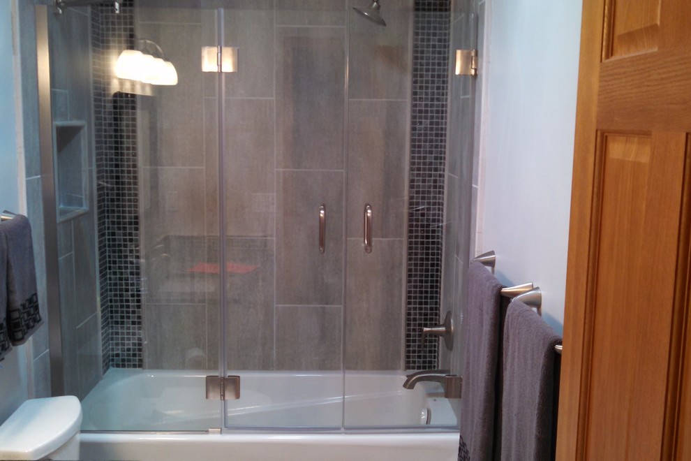 Inspiration for a contemporary bathroom in Minneapolis with a shower/bathtub combo, a hinged shower door, shaker cabinets, white cabinets, an alcove tub, gray tile, grey walls, an undermount sink and grey floor.