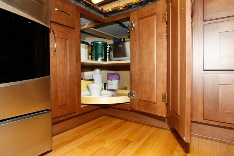 Inspiration for a transitional u-shaped eat-in kitchen remodel in Chicago with an undermount sink, recessed-panel cabinets, medium tone wood cabinets, granite countertops, beige backsplash, stone tile backsplash and stainless steel appliances