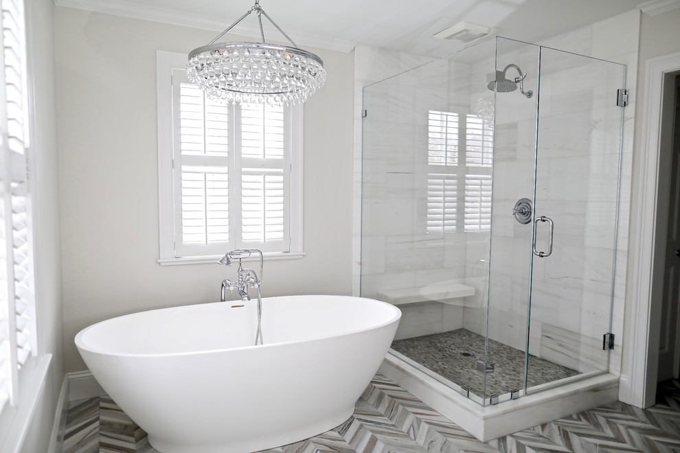 Inspiration for a large transitional master white tile and marble tile marble floor and multicolored floor freestanding bathtub remodel with furniture-like cabinets, distressed cabinets, gray walls, an undermount sink, marble countertops, a hinged shower door and white countertops