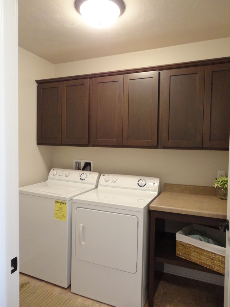 Design ideas for a mid-sized traditional single-wall dedicated laundry room in Milwaukee with dark wood cabinets, laminate benchtops, beige walls, vinyl floors, a side-by-side washer and dryer and shaker cabinets.