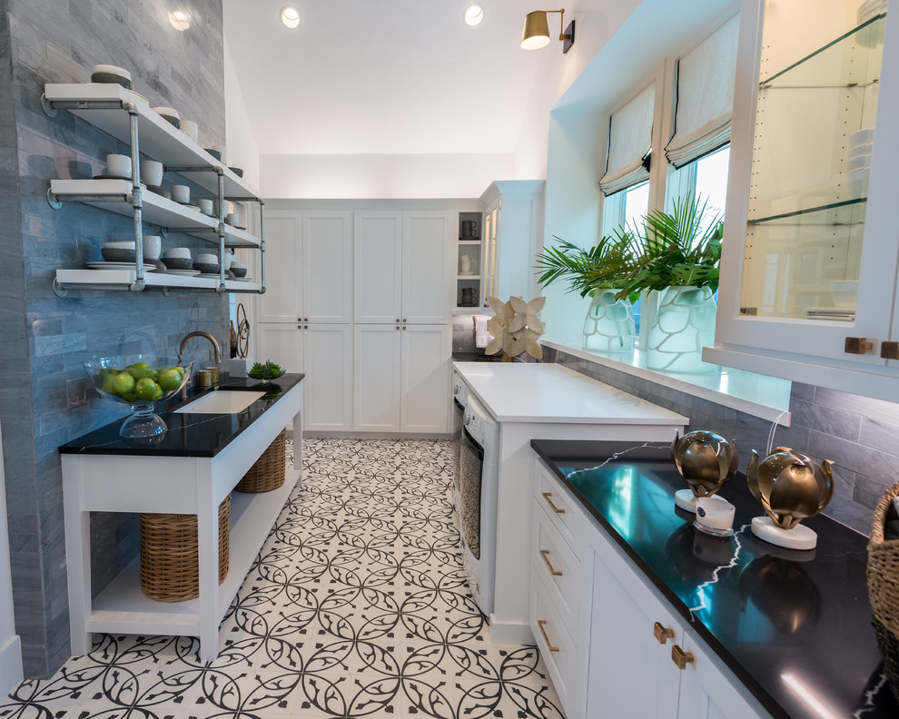 Inspiration for a galley kitchen in Austin with an undermount sink, recessed-panel cabinets, white cabinets, soapstone benchtops, porcelain floors, white floor and black benchtop.