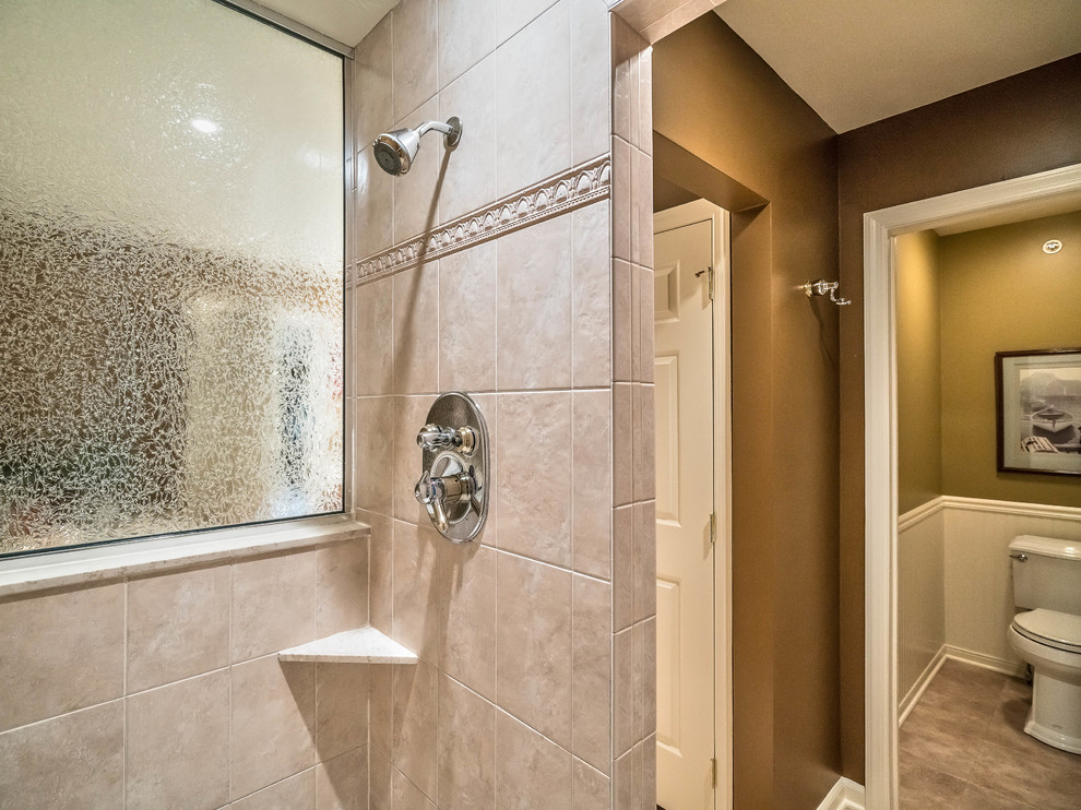 This is an example of a mid-sized eclectic master wet room bathroom in Other with raised-panel cabinets, medium wood cabinets, a drop-in tub, a two-piece toilet, beige tile, ceramic tile, brown walls, porcelain floors, an undermount sink and engineered quartz benchtops.