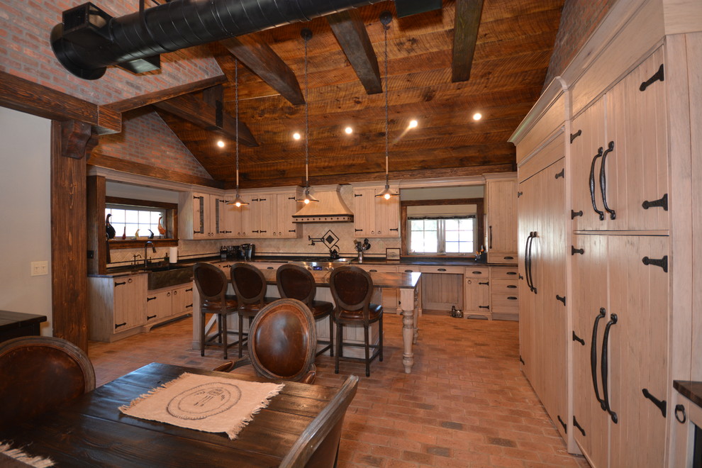 Example of a large mountain style brick floor eat-in kitchen design in New York with a farmhouse sink, beige cabinets, quartzite countertops and limestone backsplash