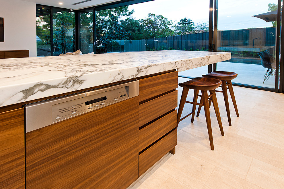 Inspiration for a large modern galley eat-in kitchen in Perth with a double-bowl sink, flat-panel cabinets, dark wood cabinets, marble benchtops, white splashback, stone slab splashback, stainless steel appliances, porcelain floors and with island.