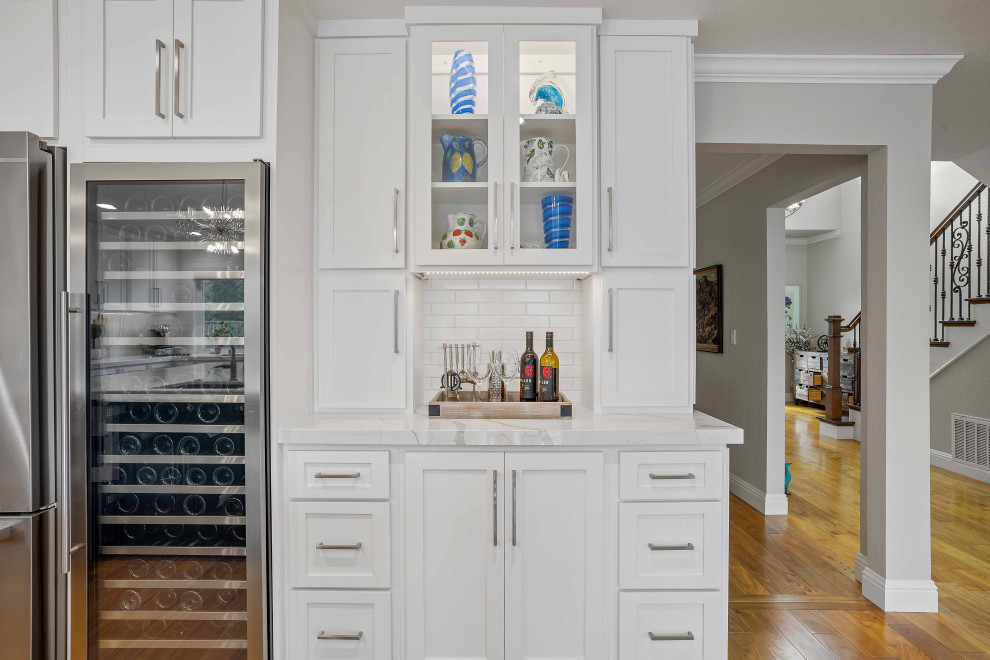 Idéer för ett stort klassiskt vit kök, med en enkel diskho, skåp i shakerstil, blå skåp, bänkskiva i kvarts, vitt stänkskydd, rostfria vitvaror, mellanmörkt trägolv, en köksö och brunt golv