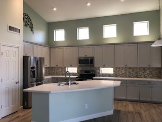 Mid-sized transitional u-shaped porcelain tile and gray floor open concept kitchen photo in Phoenix with a drop-in sink, shaker cabinets, gray cabinets, quartz countertops, green backsplash, glass tile backsplash, stainless steel appliances and an island