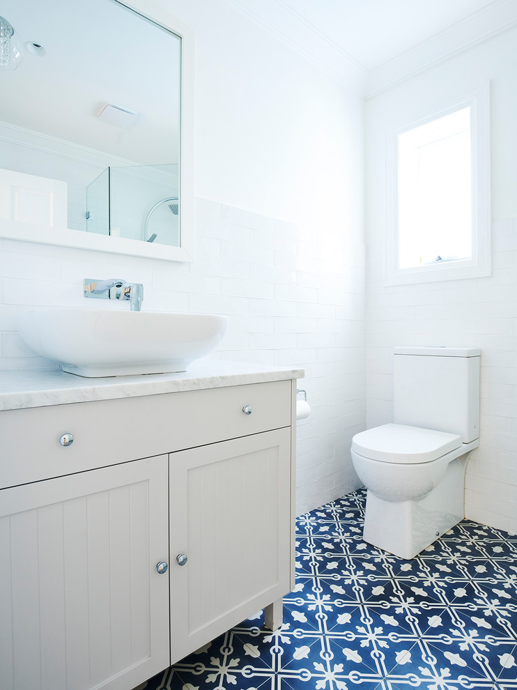 Design ideas for a mid-sized transitional kids bathroom in Sydney with furniture-like cabinets, a freestanding tub, a corner shower, a two-piece toilet, ceramic tile, white walls, cement tiles, a drop-in sink, wood benchtops, white cabinets, white tile and blue floor.