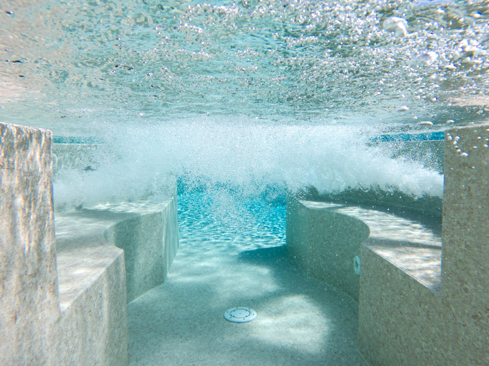 На фото: большой бассейн-инфинити произвольной формы на переднем дворе в классическом стиле с покрытием из каменной брусчатки