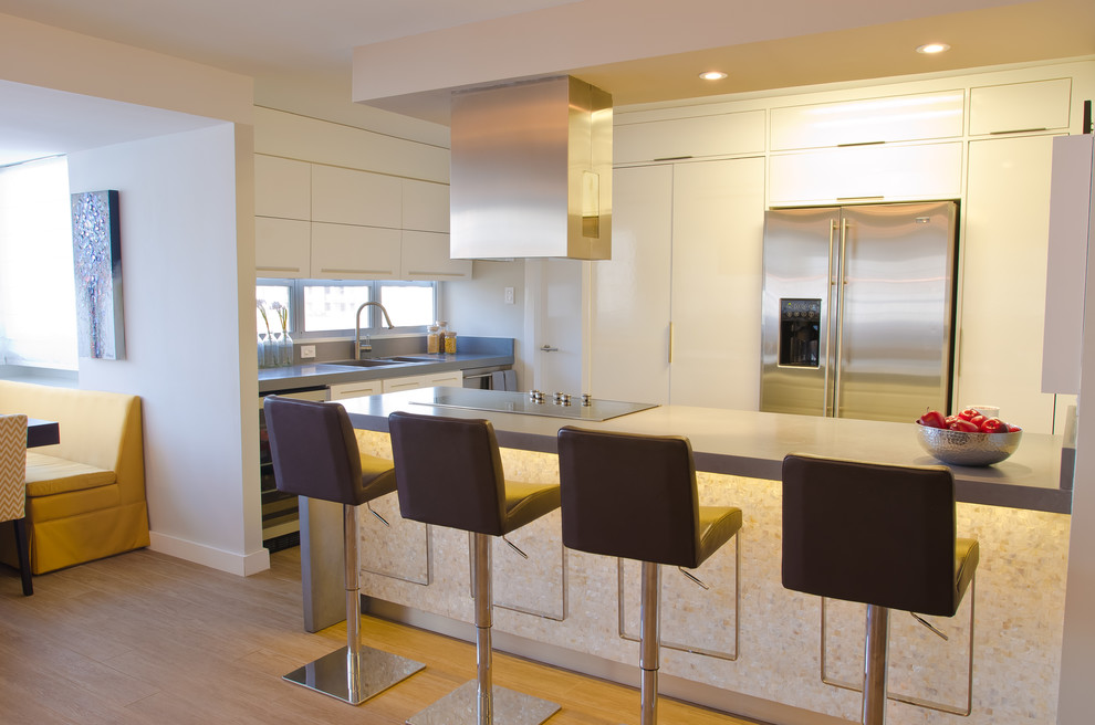 This is an example of a small contemporary u-shaped open plan kitchen in Other with a peninsula, flat-panel cabinets, white cabinets, quartz benchtops, stainless steel appliances, a double-bowl sink and ceramic floors.