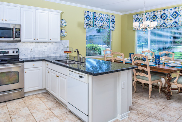 Mid-sized transitional eat-in kitchen photo in Austin with raised-panel cabinets, white cabinets, white backsplash, marble backsplash, stainless steel appliances, a peninsula and a double-bowl sink