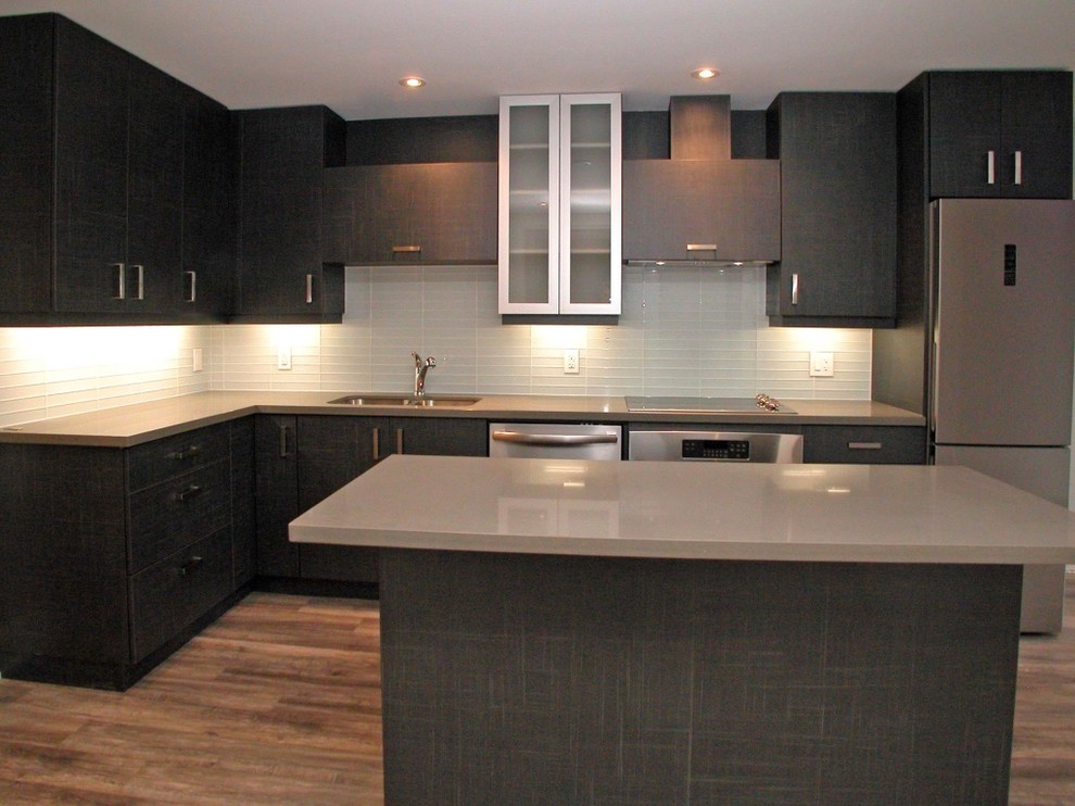 Mid-sized contemporary l-shaped open plan kitchen in Toronto with an undermount sink, flat-panel cabinets, grey cabinets, quartz benchtops, white splashback, glass tile splashback, stainless steel appliances, vinyl floors and with island.