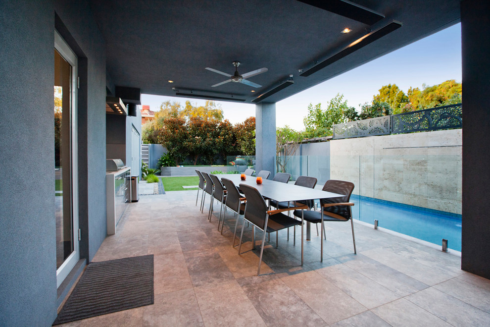 This is an example of a mid-sized contemporary backyard patio in Perth with natural stone pavers.