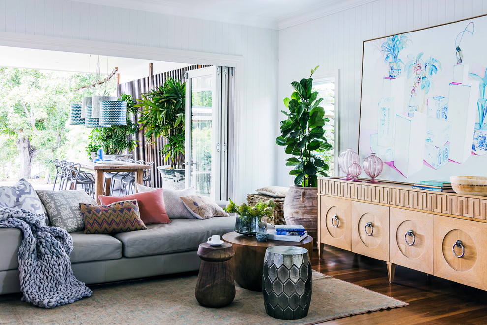 Tropical open concept living room in Melbourne with white walls and medium hardwood floors.