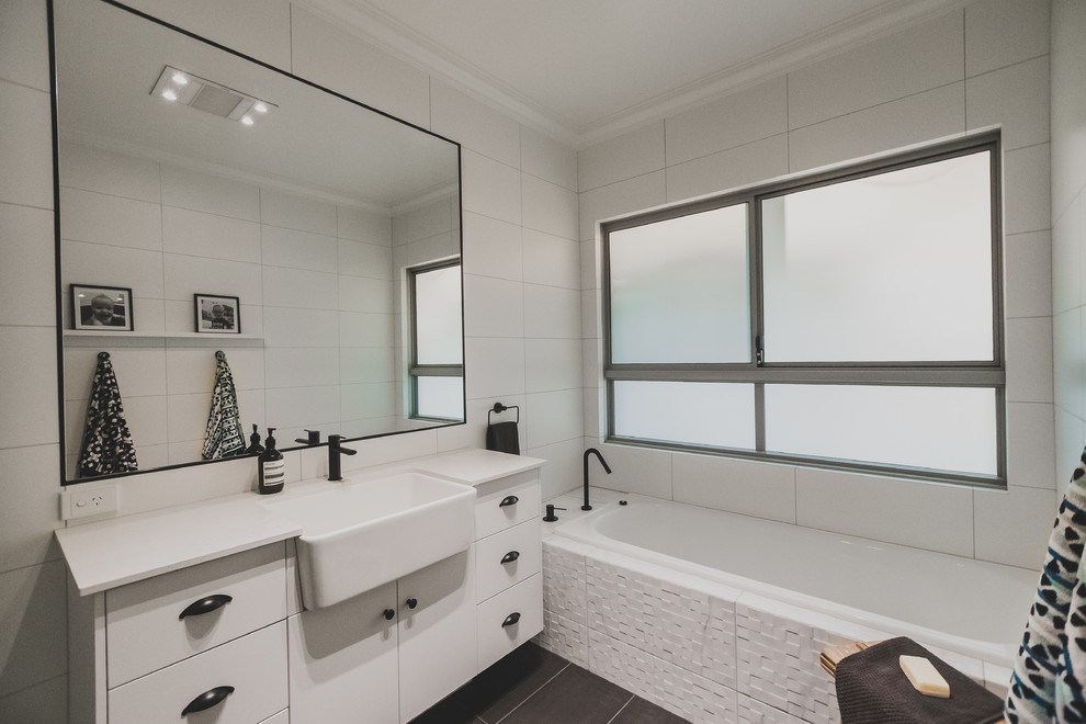 Inspiration for a large modern kids bathroom in Other with white cabinets, an alcove shower, white tile, ceramic tile, white walls, ceramic floors, an undermount sink, marble benchtops and grey floor.