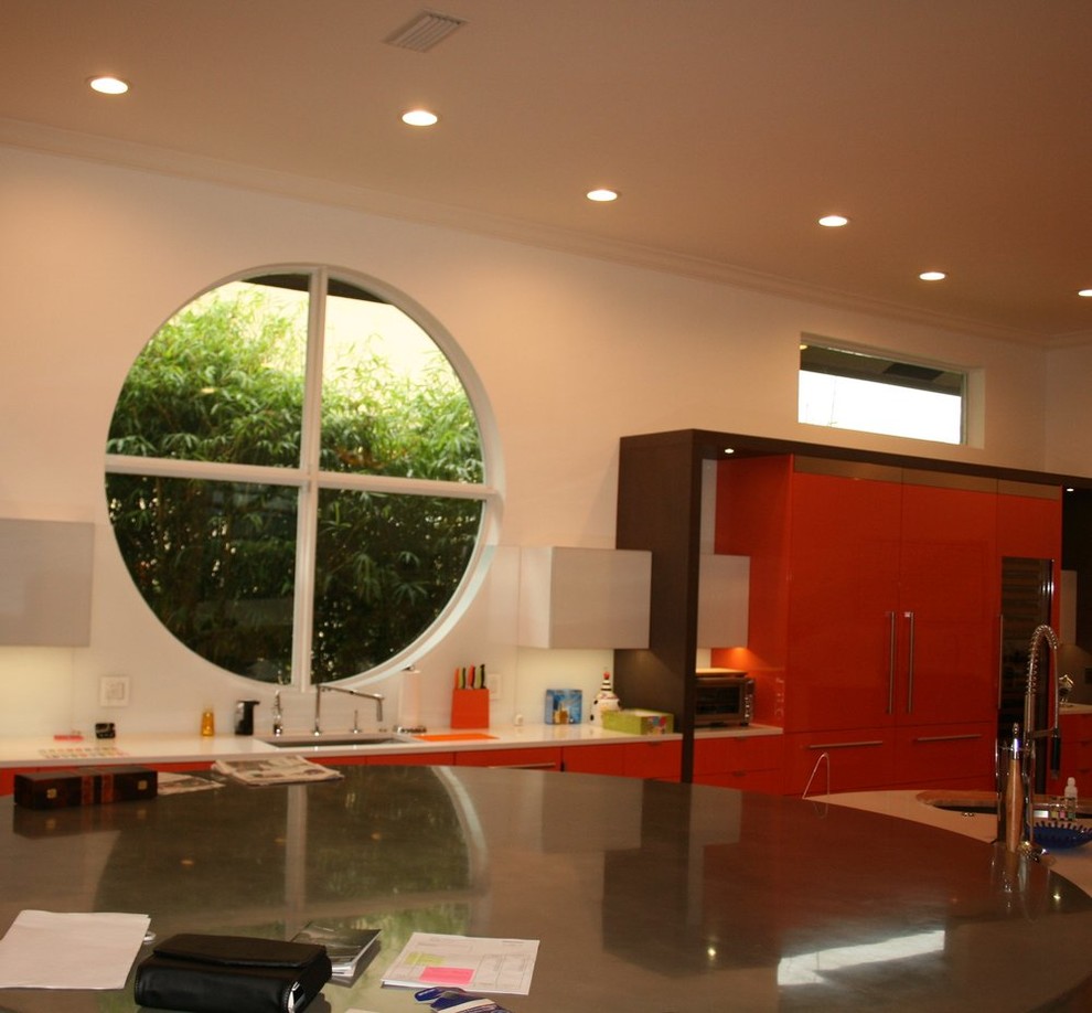 Inspiration for an u-shaped enclosed kitchen remodel with an undermount sink, flat-panel cabinets, red cabinets, limestone countertops and an island