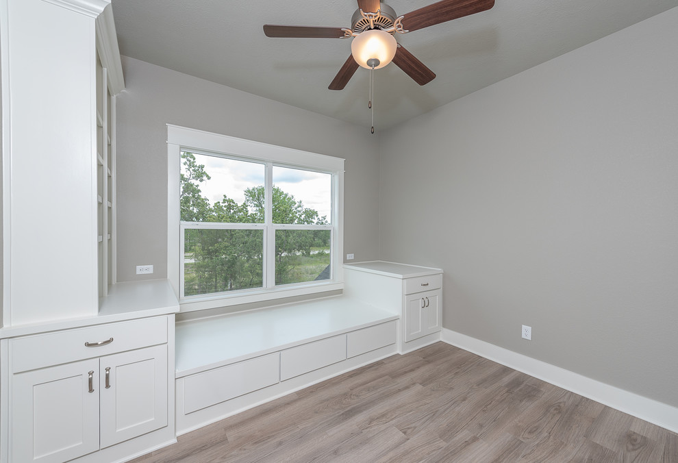 Mid-sized arts and crafts guest bedroom in Other with grey walls, laminate floors and brown floor.