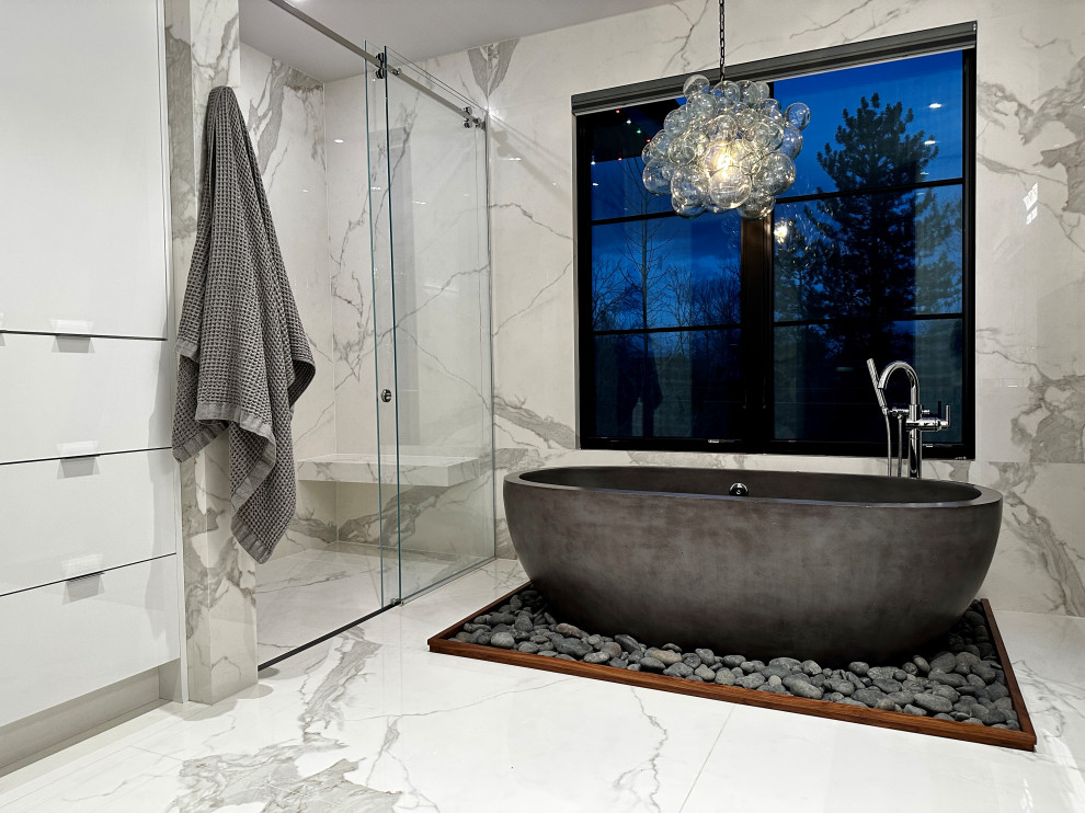 Exemple d'une salle de bain principale moderne avec un placard à porte plane, des portes de placard blanches, une baignoire indépendante, une douche à l'italienne, des dalles de pierre, un mur blanc, une cabine de douche à porte coulissante, meuble double vasque et meuble-lavabo suspendu.