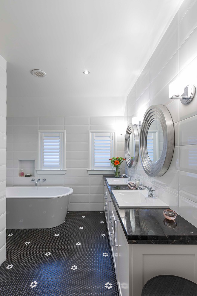 Inspiration for a contemporary bathroom in Auckland with a drop-in sink, a freestanding tub, white walls, mosaic tile floors, shaker cabinets and white cabinets.