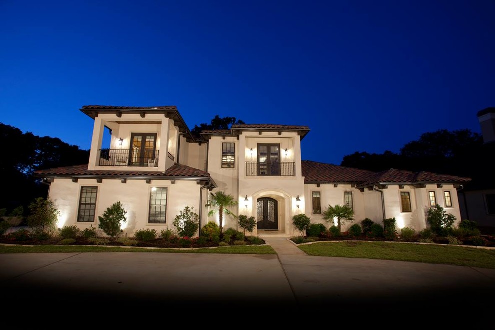 Photo of a large mediterranean two-storey stucco beige house exterior in Austin with a tile roof.