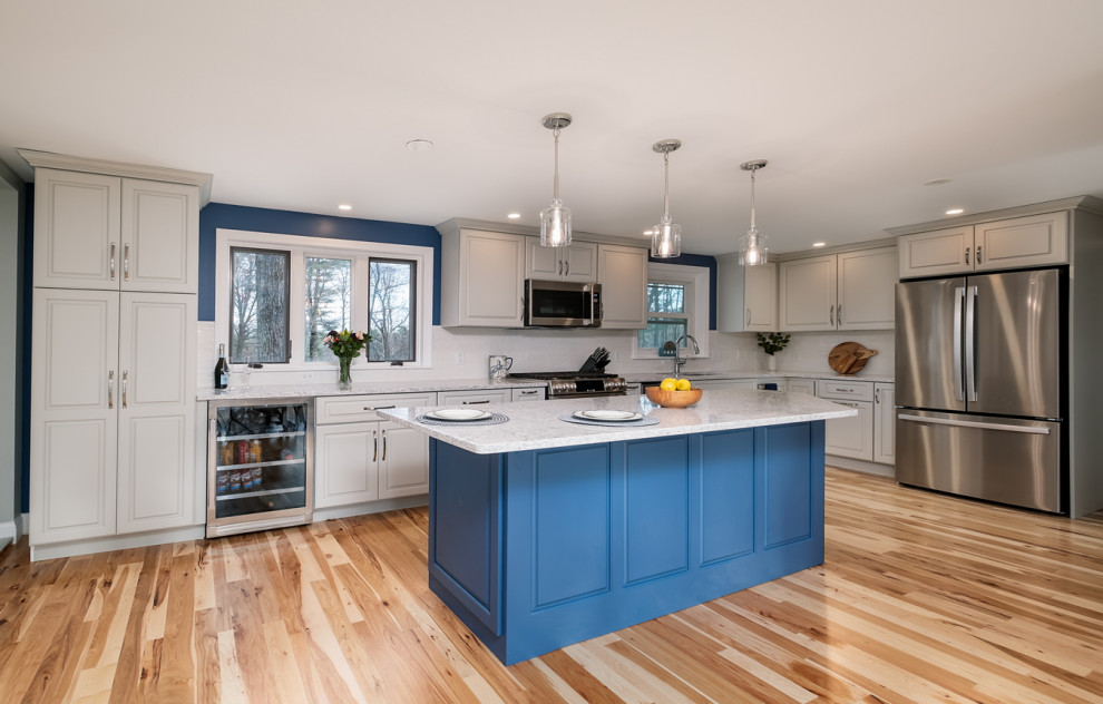 Eat-in kitchen - mid-sized transitional l-shaped light wood floor eat-in kitchen idea in Boston with a single-bowl sink, raised-panel cabinets, gray cabinets, quartz countertops, white backsplash, ceramic backsplash, stainless steel appliances, an island and white countertops