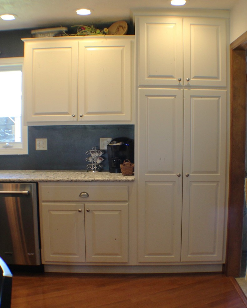 Inspiration for a large rustic l-shaped light wood floor home design remodel in Chicago with a farmhouse sink, raised-panel cabinets, white cabinets, quartz countertops, stainless steel appliances and an island