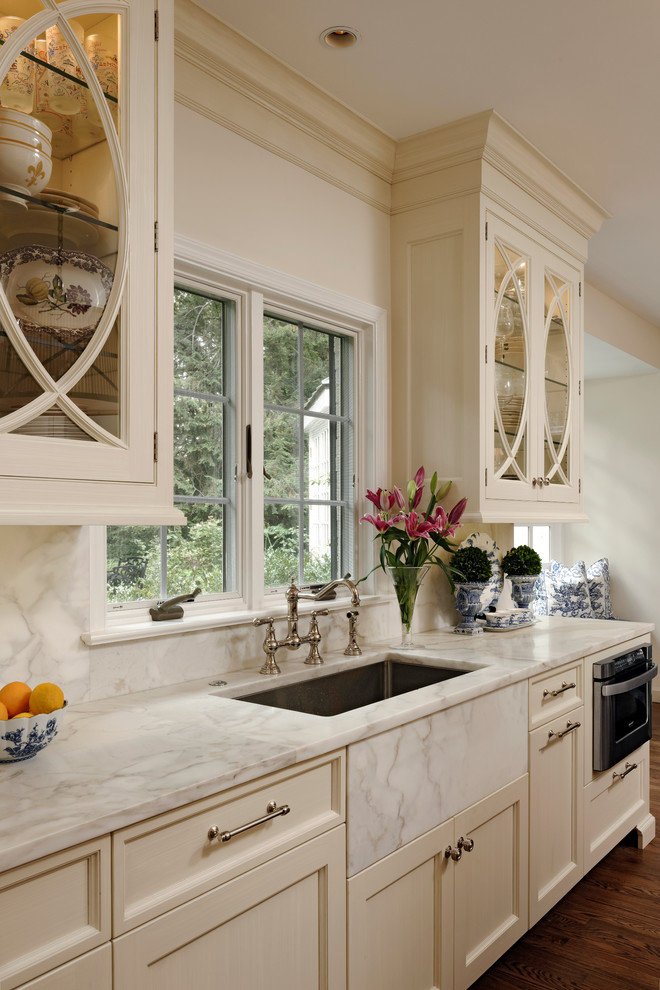 Inspiration for a mid-sized traditional u-shaped eat-in kitchen in DC Metro with beaded inset cabinets, white cabinets, marble benchtops, white splashback, stone slab splashback, stainless steel appliances, medium hardwood floors, with island and an undermount sink.