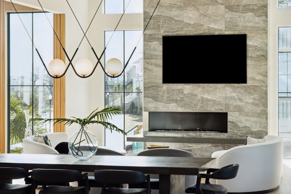 На фото: кухня-столовая в стиле модернизм с белыми стенами, светлым паркетным полом, угловым камином, фасадом камина из плитки и панелями на части стены с