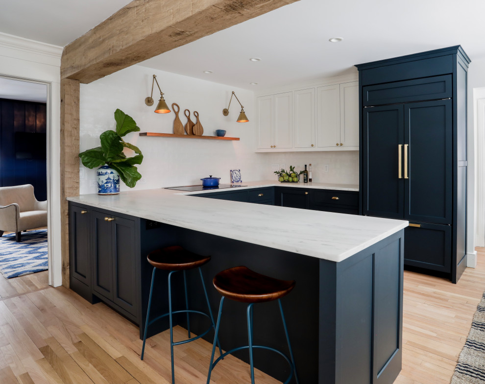 Eat-in kitchen - small transitional u-shaped marble floor, beige floor and exposed beam eat-in kitchen idea in New York with a farmhouse sink, shaker cabinets, blue cabinets, marble countertops, white backsplash, ceramic backsplash, paneled appliances, no island and white countertops