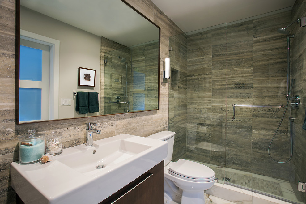 Inspiration for a mid-sized contemporary 3/4 bathroom in Orange County with flat-panel cabinets, brown cabinets, an alcove tub, an alcove shower, a one-piece toilet, gray tile, travertine, grey walls, marble floors, a console sink, white floor and a hinged shower door.