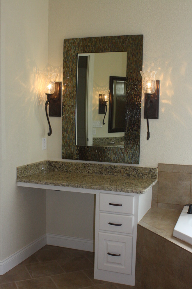 Photo of a contemporary master bathroom in New Orleans with raised-panel cabinets, white cabinets, granite benchtops, a corner tub, beige tile, ceramic tile, beige walls and ceramic floors.