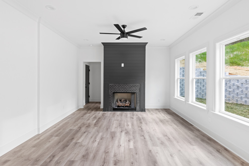 Exempel på ett mellanstort klassiskt allrum med öppen planlösning, med vita väggar, vinylgolv, en standard öppen spis, en spiselkrans i trä och brunt golv