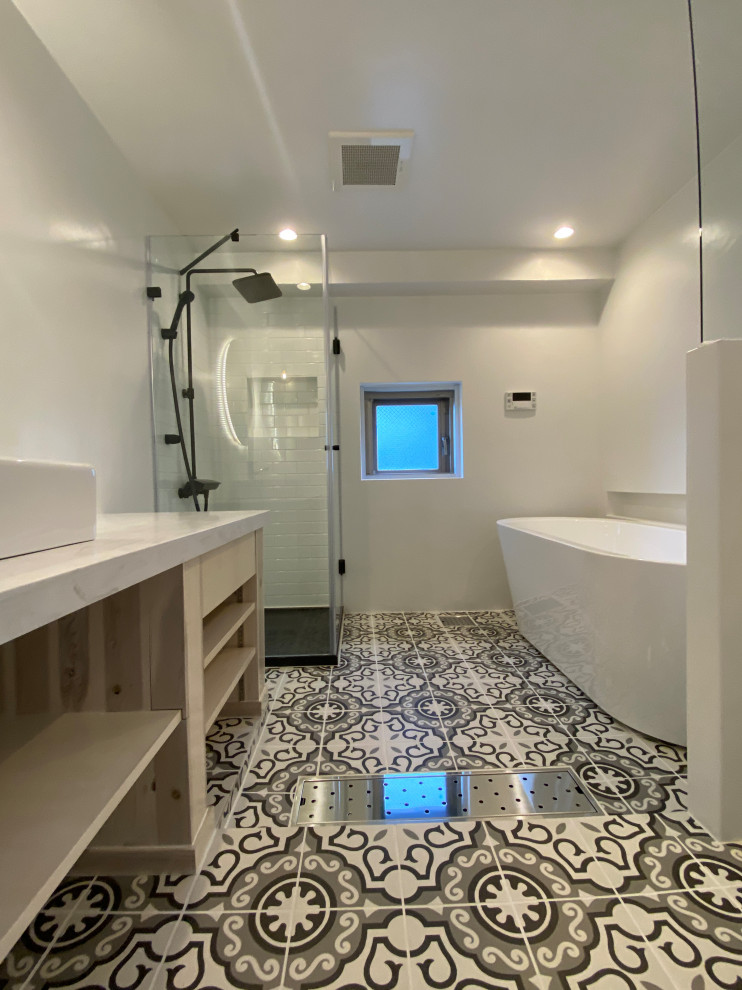 Photo of a mid-sized modern master bathroom in Tokyo with open cabinets, white cabinets, a freestanding tub, a corner shower, a one-piece toilet, white tile, subway tile, white walls, cement tiles, a vessel sink, limestone benchtops, multi-coloured floor, a hinged shower door, white benchtops, an enclosed toilet, a single vanity, a built-in vanity, timber and planked wall panelling.