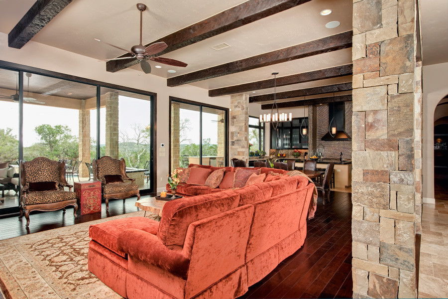 This is an example of a mid-sized traditional formal open concept living room in Austin with beige walls, dark hardwood floors, no fireplace, a wall-mounted tv and brown floor.
