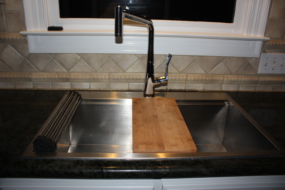 Large transitional u-shaped light wood floor eat-in kitchen photo with a double-bowl sink, raised-panel cabinets, gray cabinets, quartz countertops, beige backsplash, ceramic backsplash, stainless steel appliances and an island