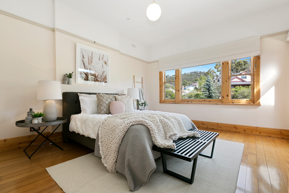 Inspiration for a transitional bedroom in Hobart with beige walls, medium hardwood floors and brown floor.