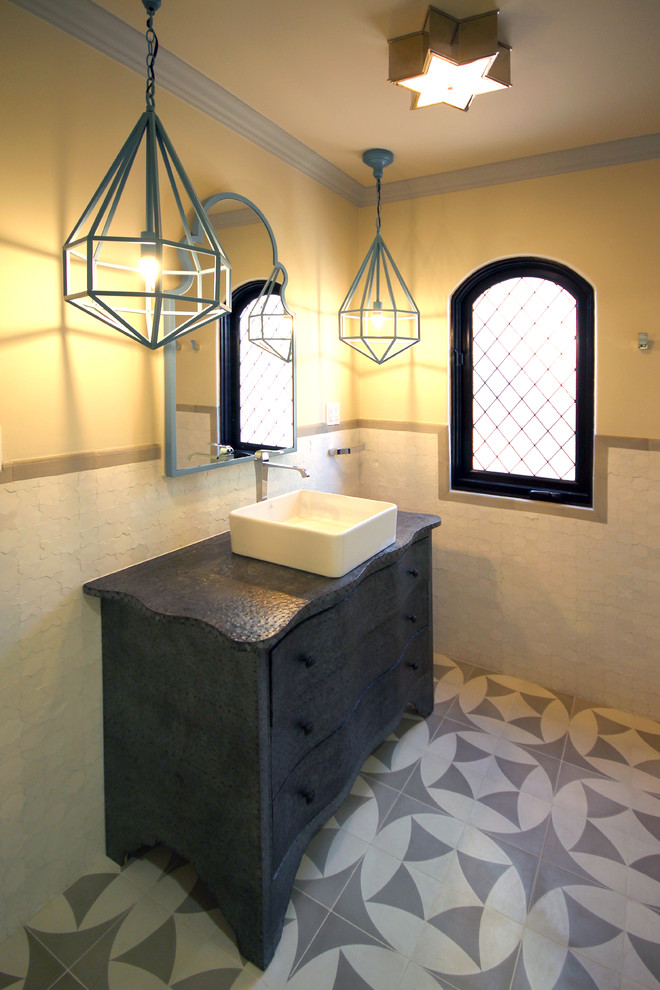This is an example of a small mediterranean 3/4 bathroom in San Diego with a vessel sink, furniture-like cabinets, grey cabinets, zinc benchtops, a drop-in tub, a shower/bathtub combo, white tile, cement tile, white walls and ceramic floors.
