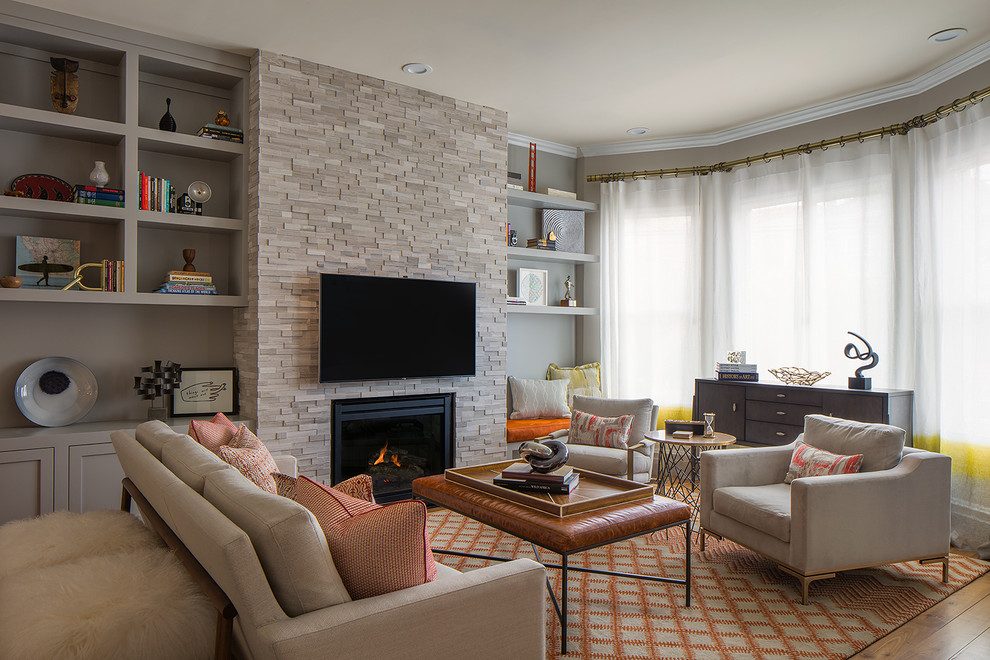 Transitional family room in San Francisco with grey walls, a standard fireplace and a wall-mounted tv.