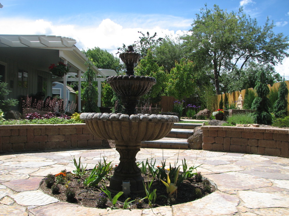 Photo of a mid-sized traditional backyard patio in Boise with natural stone pavers.
