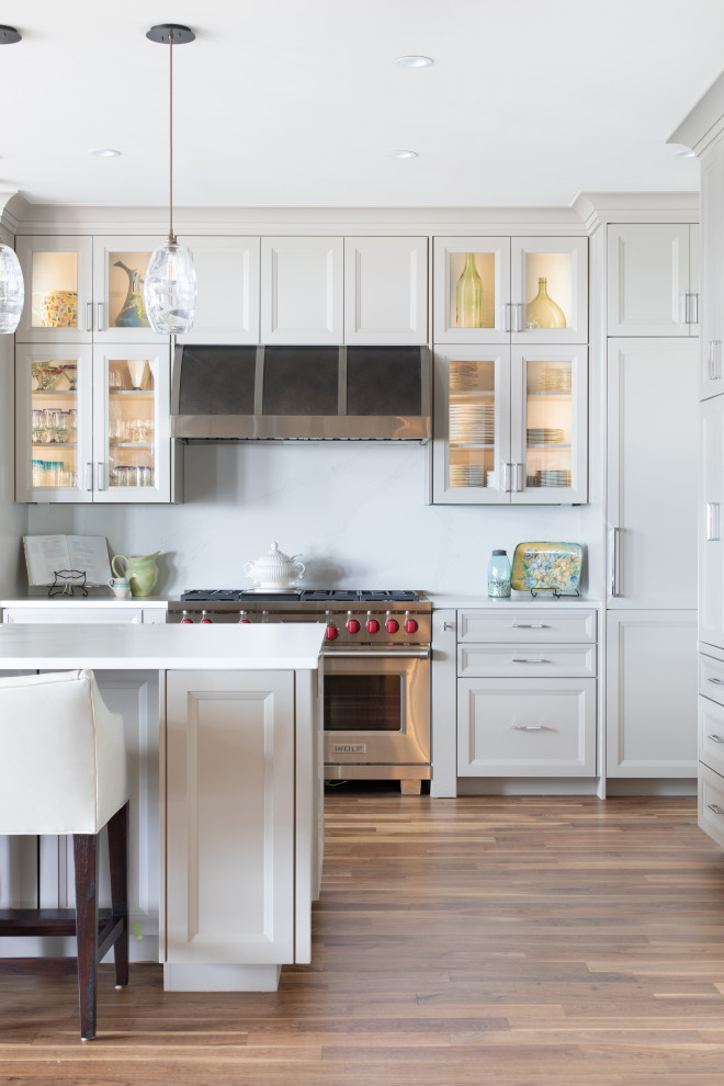 Inspiration for a contemporary medium tone wood floor and brown floor kitchen pantry remodel in Austin with white cabinets, marble countertops, white backsplash, stainless steel appliances, two islands and white countertops