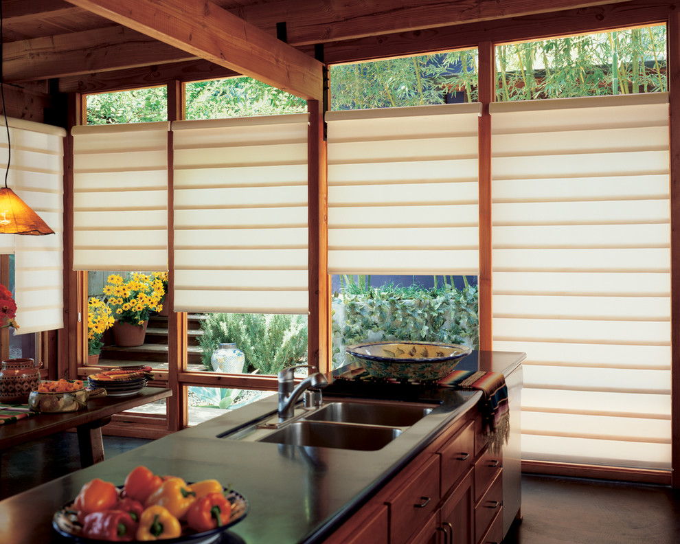 Example of a large transitional dark wood floor and brown floor eat-in kitchen design with a double-bowl sink, medium tone wood cabinets, solid surface countertops, stainless steel appliances, an island, recessed-panel cabinets and black countertops
