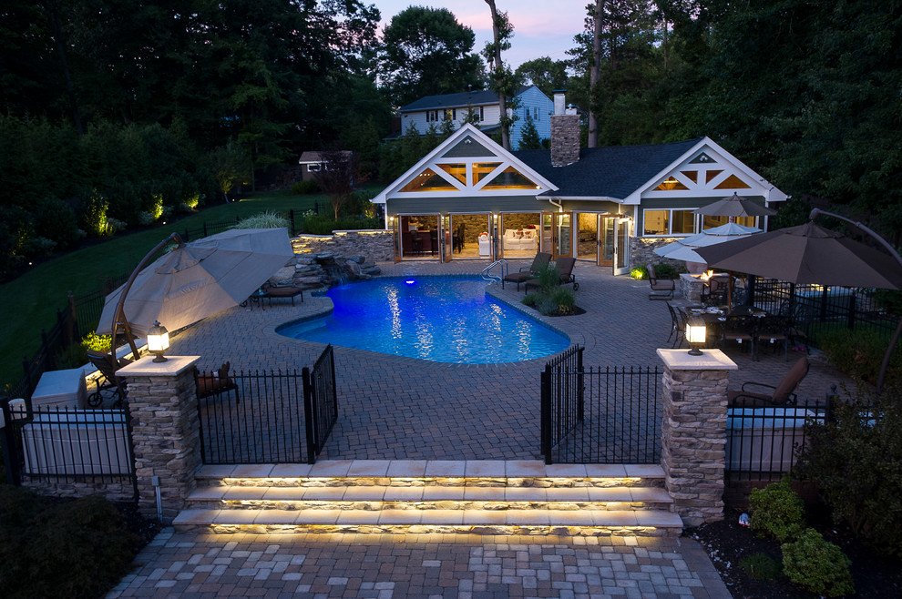 Photo of an arts and crafts backyard custom-shaped pool in New York with a pool house.