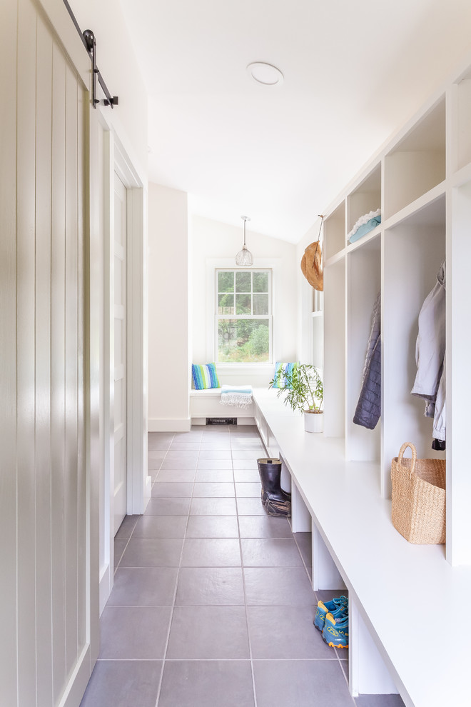 Design ideas for a mid-sized transitional mudroom in Boston with white walls, ceramic floors and grey floor.