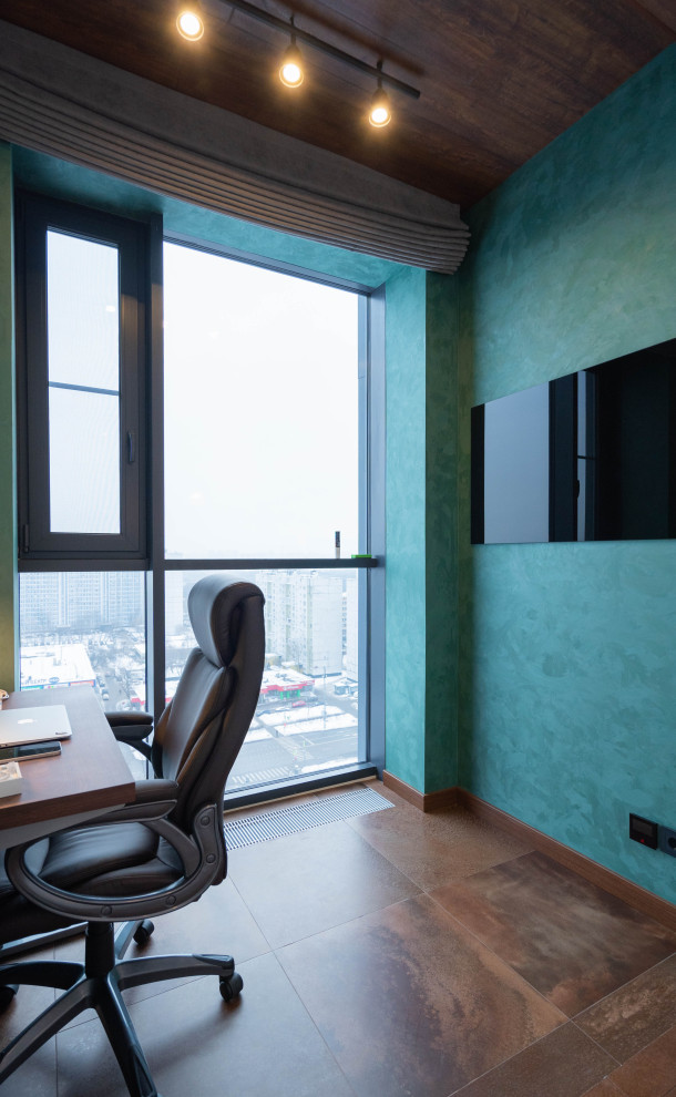 Réalisation d'un petit bureau atelier design avec un mur vert, un sol en liège, un bureau intégré et un sol marron.